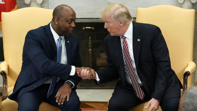President Donald Trump shakes hands with Sen. Tim Scott in the Oval Office of the White House on Feb. 14, 2018. 