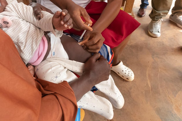A health worker administers a malaria vaccine