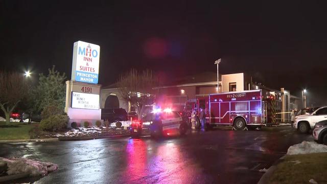 A firetruck and a police vehicle sit outside a motel in Middlesex County. 