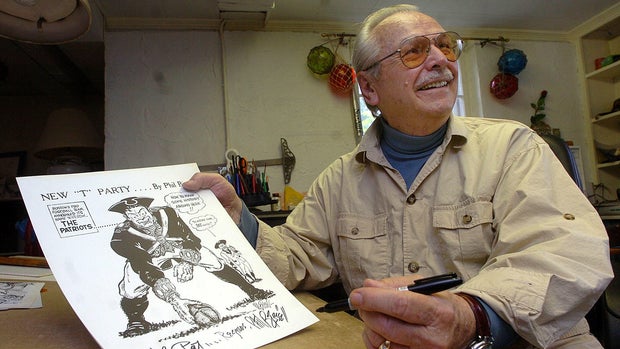 (07/01/09 Rockport, Ma) The Herald meets Patriots logo creator Phil Bissell at his studio inside his home. Bissell smiles as he displays the logo during interview. . Staff Photo by Patrick Whittemore. Saved in Thursday and ad sports and archi 