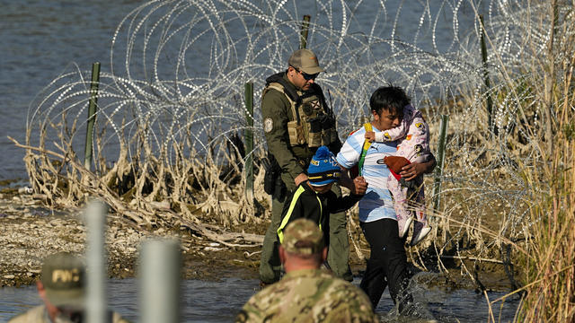 Migrants are taken into custody by officials at the U.S.-Mexico border on Wednesday, Jan. 3, 2024, in Eagle Pass, Texas. 