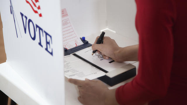 Asian voter voting in polling place 
