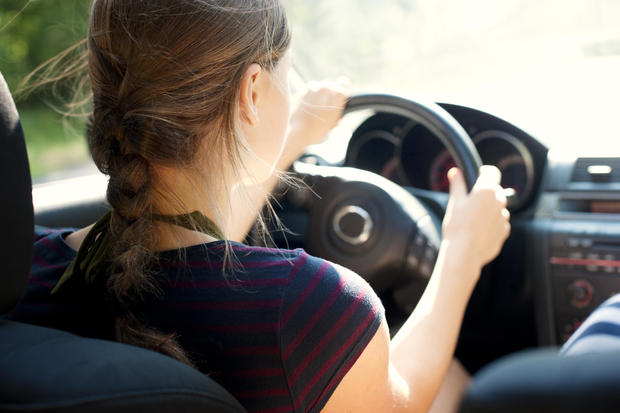 Rear view of teenage girl driving car 