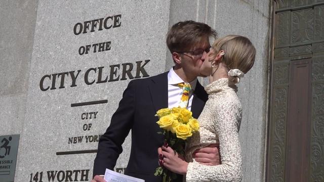 A newlywed couple kisses outside the New York City Office of the City Clerk. 