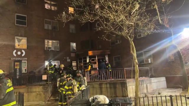 Firefighters stand outside an apartment building in Harlem. 