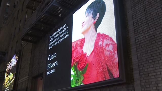 A digital billboard in the Theater District displays a photo of Chita Rivera and the caption "Broadway's lights are being dimmed tonight in memory of the legendary Tony-winning performer Chita Rivera 1933-2024." 