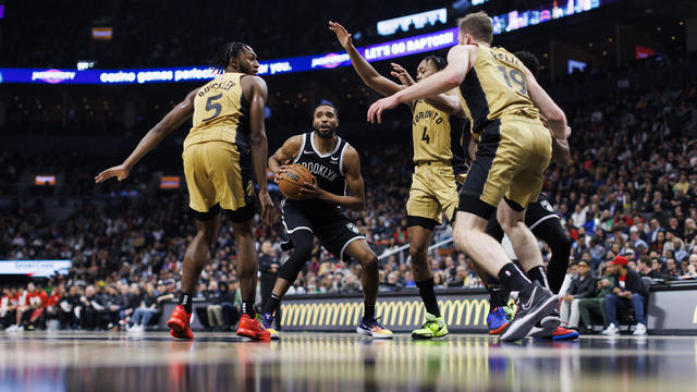 Mikal Bridges #1 of the Brooklyn Nets is defended by Immanuel Quickley #5, Jakob Poeltl #19, and Scottie Barnes #4 of the Toronto Raptors in the second half of their NBA game at Scotiabank Arena on February 22, 2024 in Toronto, Canada. 