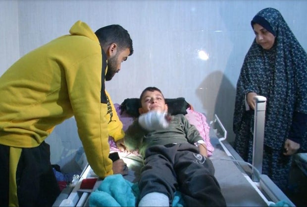 Rajaa Hamad, at right, stands next to the hospital bed of her nephew, Mohammad Hamad, 9, who was the only member of his immediate family to escape from the wreckage of their home after it was hit by an Israeli airstrike in northern Gaza, Feb. 28, 2024