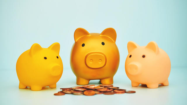 Piggy bank family with a pile of coins in a blue setting 