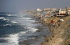 Palestinians wait for an airdrop of humanitarian aid by the Egyptian Air Force at the beach in Deir al Balah, Gaza, on Feb. 27, 2024. 