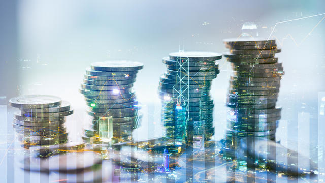 Double exposure of city with graph and stack of coins for finance and business concept 