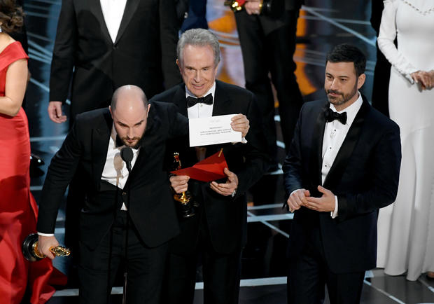 "La La Land" producer Jordan Horowitz holds up the card for actual best picture winner "Moonlight" with actor Warren Beatty and host Jimmy Kimmel onstage during the Academy Awards at Hollywood & Highland Center on Feb. 26, 2017, in Hollywood, California. 