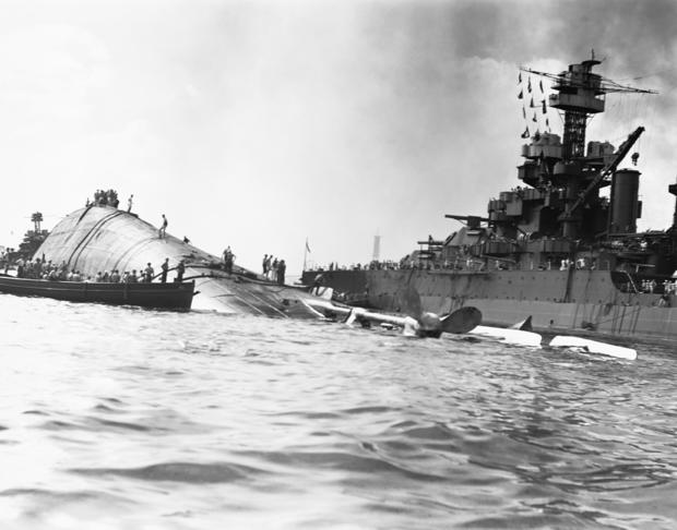 The USS Oklahoma floats capsized near the USS Maryland 