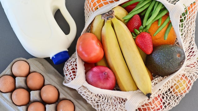 Shopping bag full of fresh vegetables and fruits with milk and eggs 