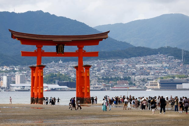 Tourists pose in front of the giant