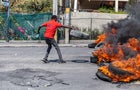 A man sets a tire on fire during a demonstration in Port-au-Prince, Haiti, on March 12, 2024. 