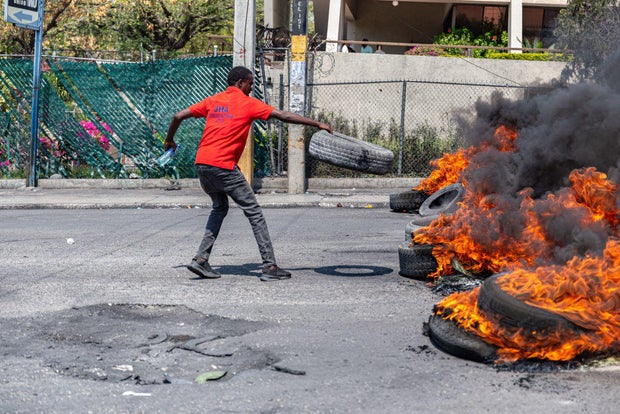 A man sets a tire on fire during a demonstration in Port-au-Prince, Haiti, on March 12, 2024.