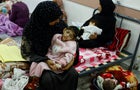 Palestinian woman Umm Mesbah Heji holds her malnourished daughter Israa, in Rafah in the southern Gaza Strip 