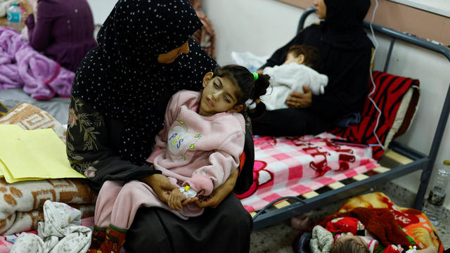 Palestinian woman Umm Mesbah Heji holds her malnourished daughter Israa, in Rafah in the southern Gaza Strip 