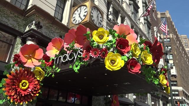 A Macy's sign outside the chain's Herald Square location is decorated with large sculpted flowers. 