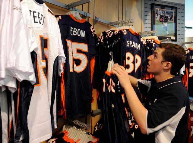 DENVER,CO--APRIL 28TH 2010--Matt Wiessenberger, retail associate for the Broncos Team Store at Invesco field at Mile High, hangs newly acquired Denver Bronco, Tim Tebow jerseys on the rack Wednesday afternoon. Andy Cross, The Denver Post