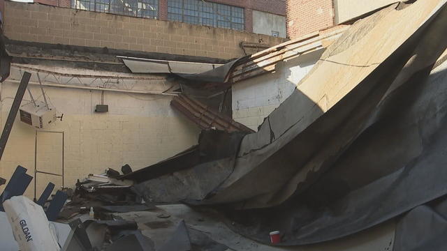 A photo of the building, where a large section of roof has caved in because of water 
