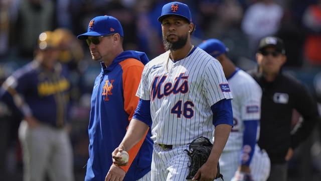 New York Mets relief pitcher Yohan Ramirez (46) leaves the game with manager Carlos Mendoza, left, after being ejected during the seventh inning of a baseball game against the Milwaukee Brewers, Saturday, March 30, 2024, in New York. 