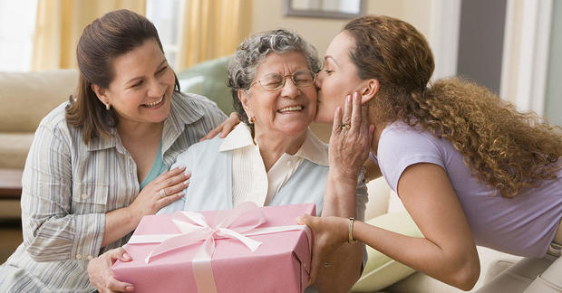 Hispanic woman giving gift to grandmother 