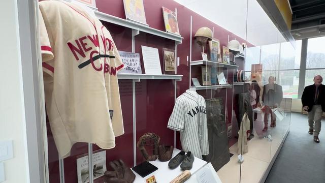 Baseball memorabilia displayed behind glass inside the Charles J. Muth Museum of Hinchliffe Stadium. 