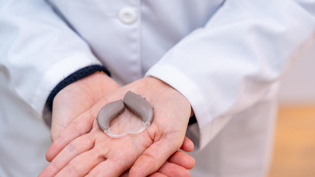 Close-up of hearing aid device in hands of a doctor specialist 