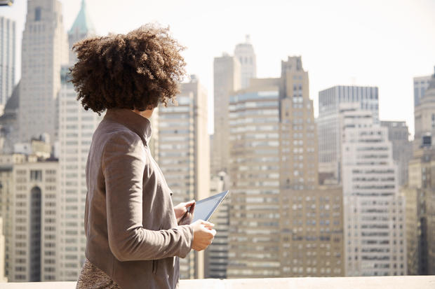 Businesswoman on rooftop holding a tablet computer 