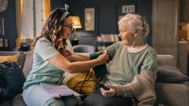 a nurse visits an elderly disabled woman at home and helps her 
