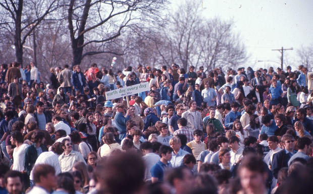 A large group of people at an Earth Day event in Philadelphia; one man holds a sign that reads 'Earth Day, Every Day; Don't Litter.' 