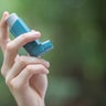 Asthma medecine inhaler holded by a man 