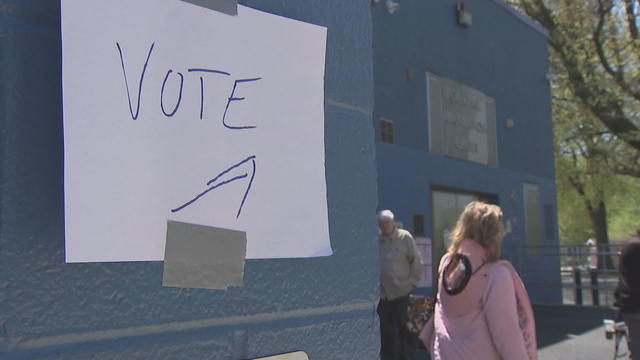 A handmade sign posted on a building says VOTE with an arrow pointing to a polling place in Philadelphia 