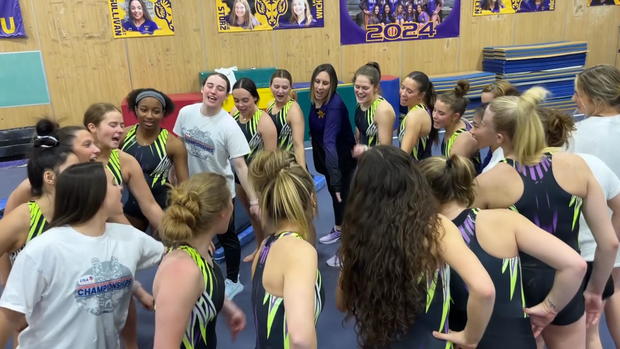 Members of the West Chester University gymnastics team put their hands into a team huddle 