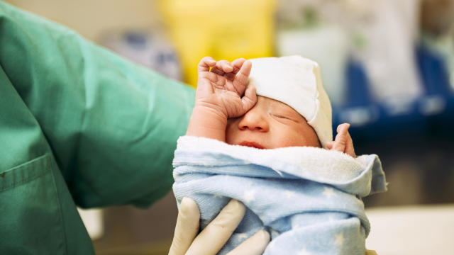 Newborn baby held by the doctor in the delivery room 
