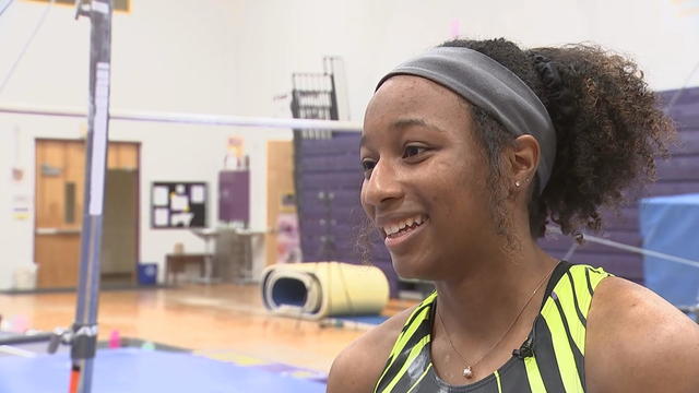 Jordan Coleman smiles while talking to a reporter in the gymnastics center at West Chester University 
