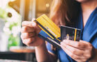 a woman holding and choosing credit card to use 
