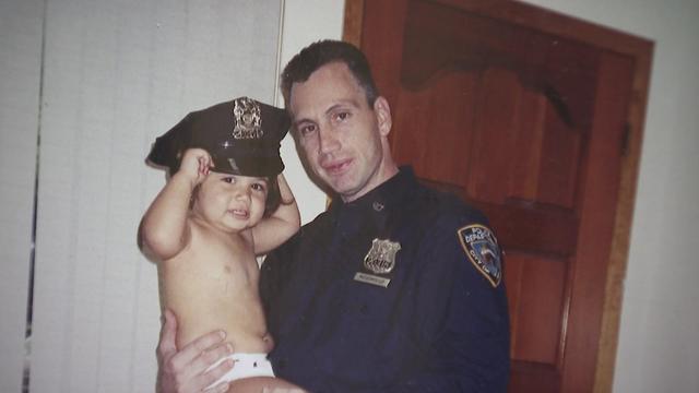 NYPD Officer Anthony Mosomillo holds his daughter, Francesca. 