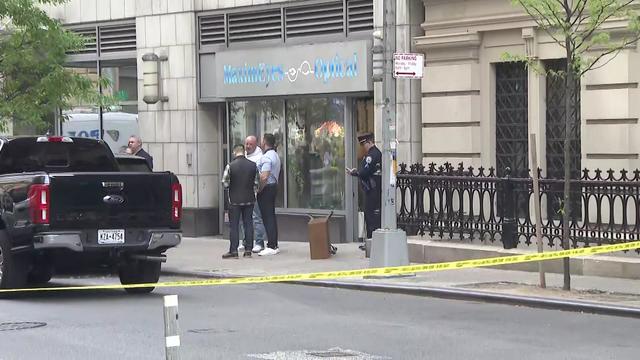 Crime scene tape blocks off West 24th Street outside an eyewear shop. 