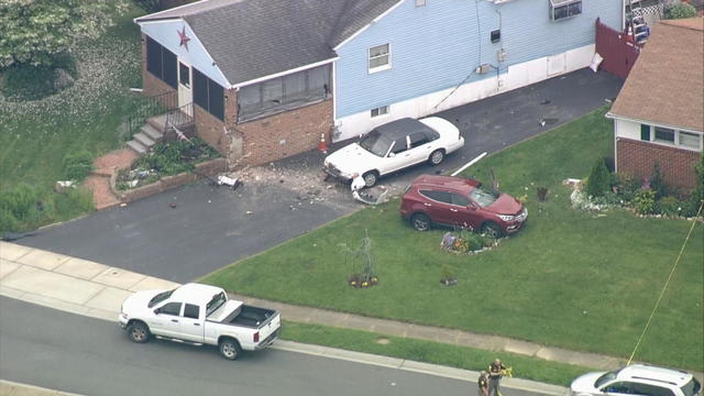 A damaged car is seen after it struck a house 