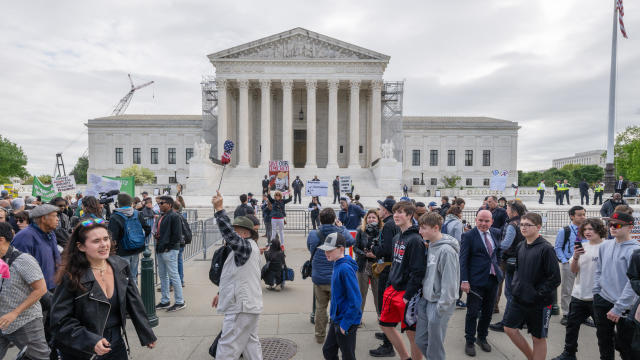 WASHINGTON, DC - APRIL 25: A tour group walks past as protestor 