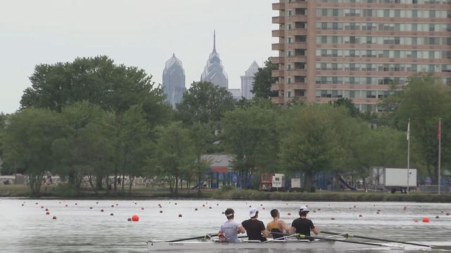 A team of rowers practices in the Cooper River, the Philadelphia skyline is seen in the distance 