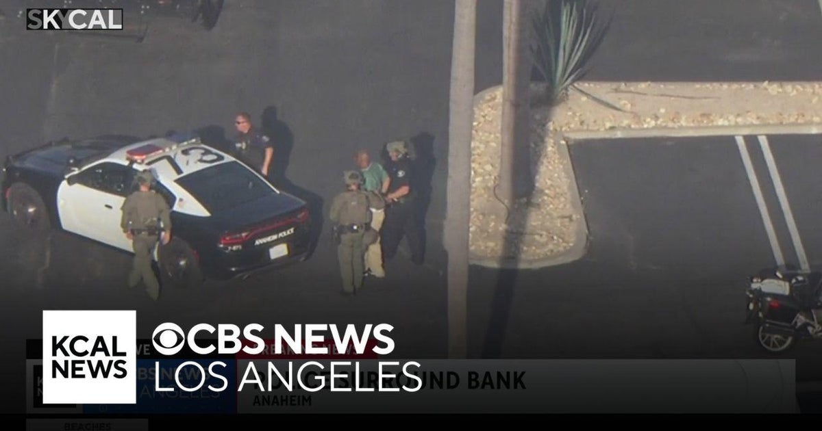 Police lead people out of the Anaheim bank after responding to an ...