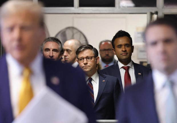 Speaker of the House Mike Johnson and former presidential candidate Vivek Ramaswamy listen as former President Donald Trump speaks to reporters on May 14, 2024.  
