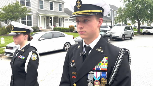 Two members of a NJROTC program in New Jersey stand in a residential street in their uniforms 