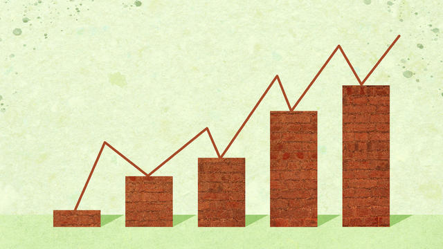 A rising bar graph made of bricks supporting a zigzag line 