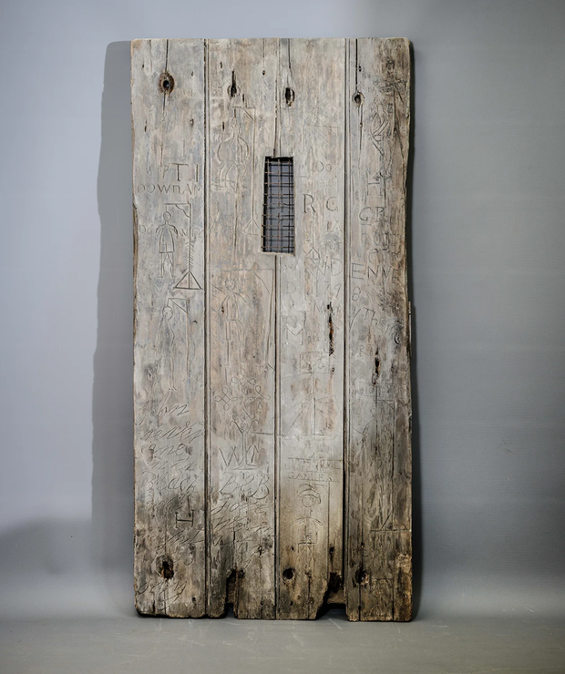 An 18th-century door engraved with more than 50 markings, including at least nine gruesome illustrations of people being hanged