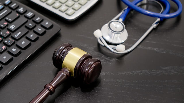 Wooden judge gavel, calculator and stethoscope on table. black background, the concept of medical malpractice, a workplace lawyer. fraudulent activity patients 